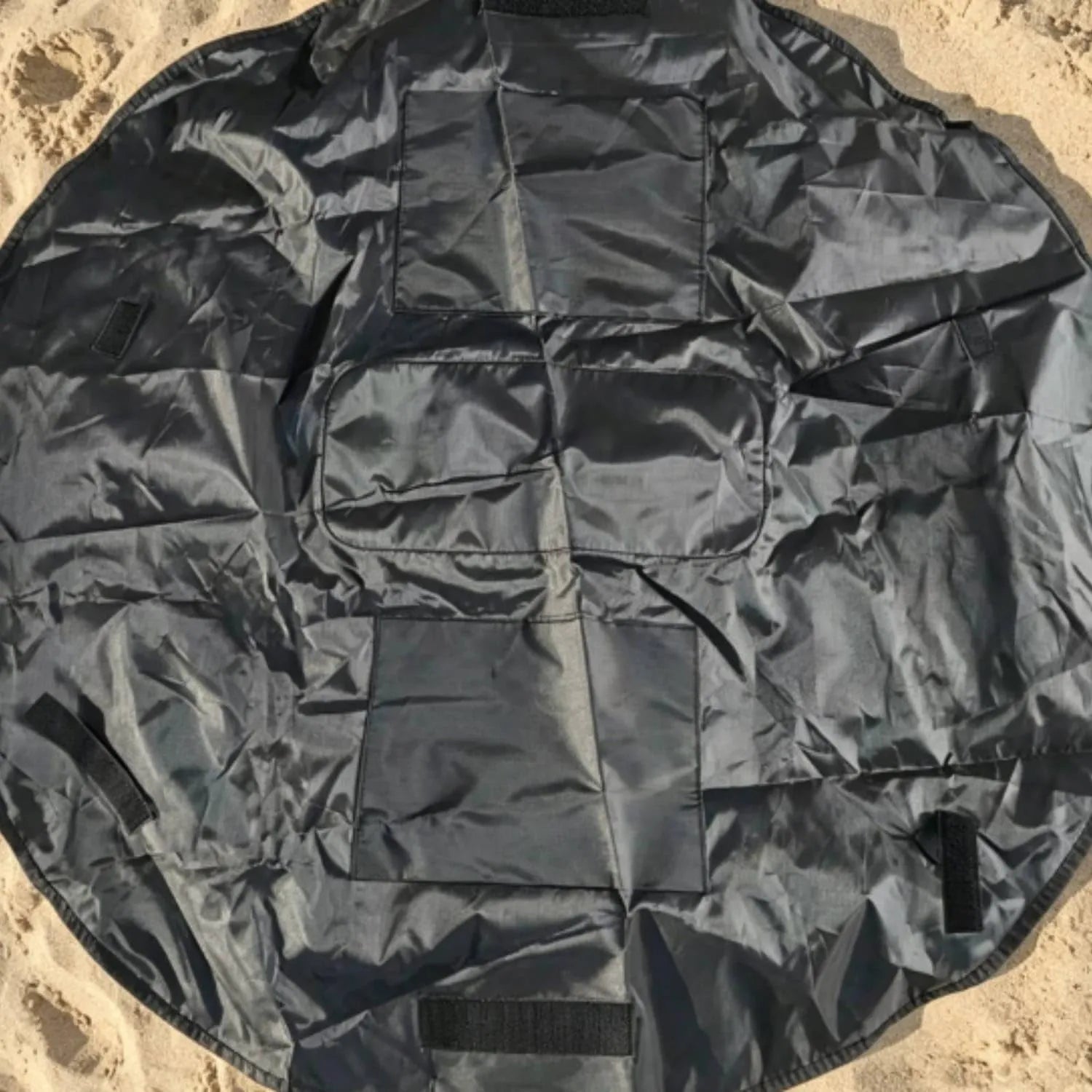 Black round organizer mat with multiple sewn storage sections