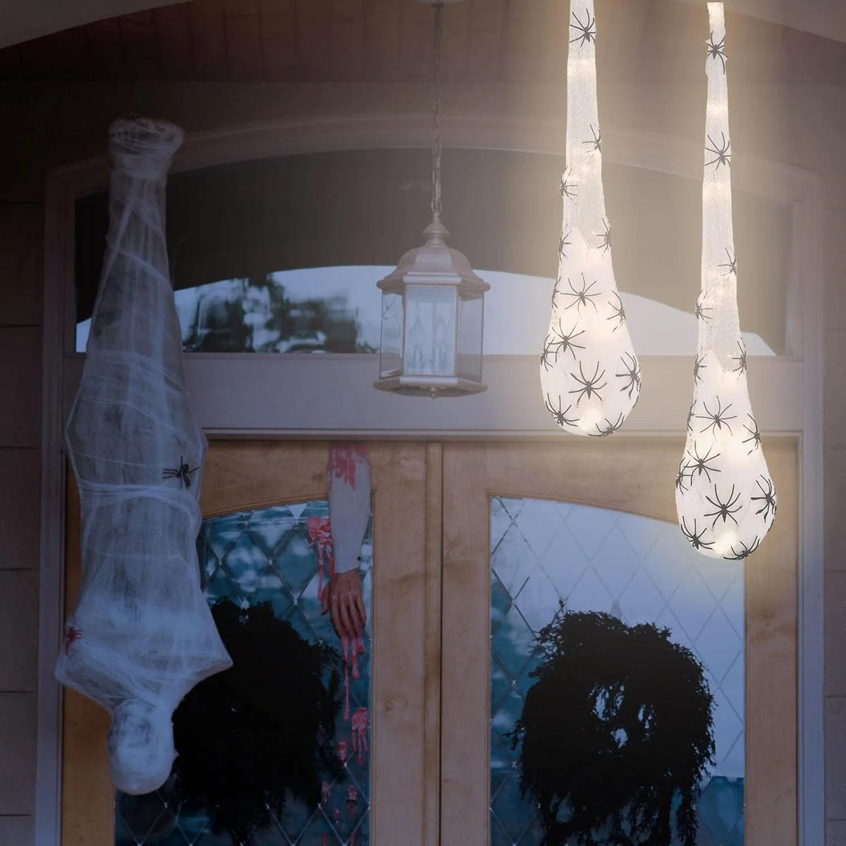 Spider egg sac lights hanging over a Halloween porch