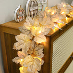 Warm-white maple leaf garland draped over a wooden cabinet